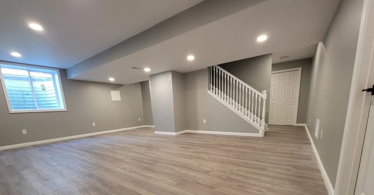 Empty basement room with wood flooring, recessed lighting, gray walls, and a staircase